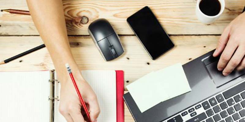 celular, mouse, e um braço mexendo no notebook