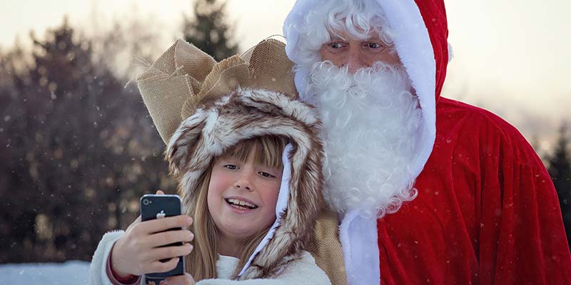 menino feliz tirando foto com um papai noel