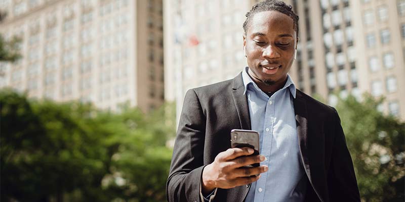 empresário usa o celular para enviar mensagens e atender aos clientes