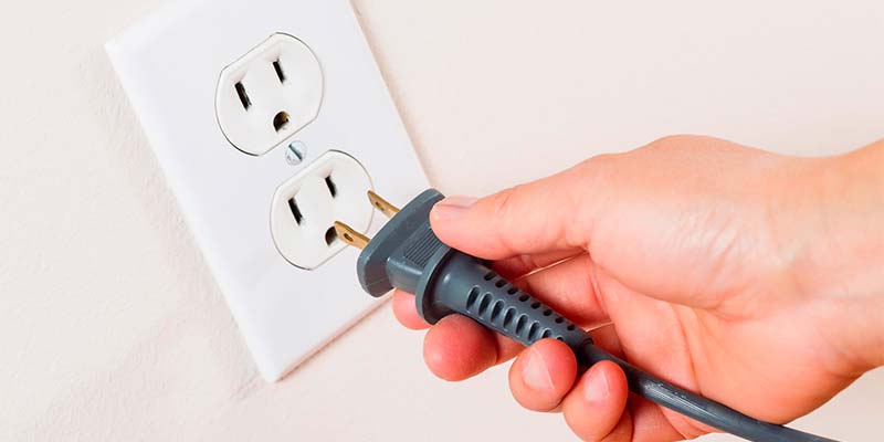 Pessoa retirando um fio da tomada