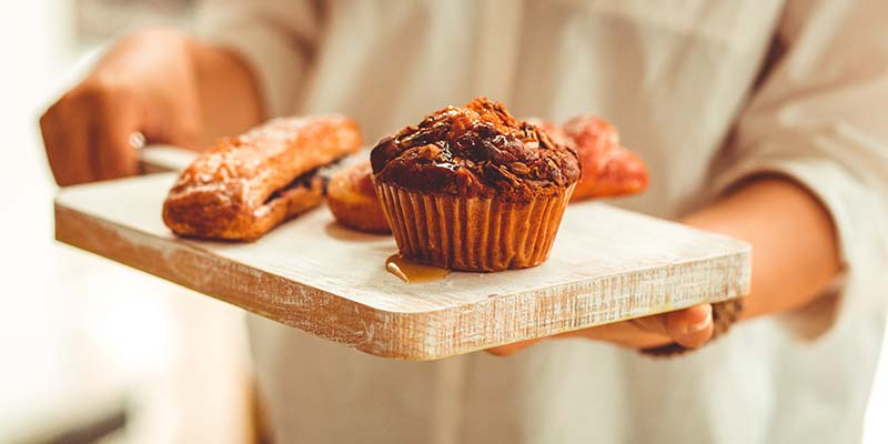 cozinheiro segurando uma tábua com bolo de chocolate