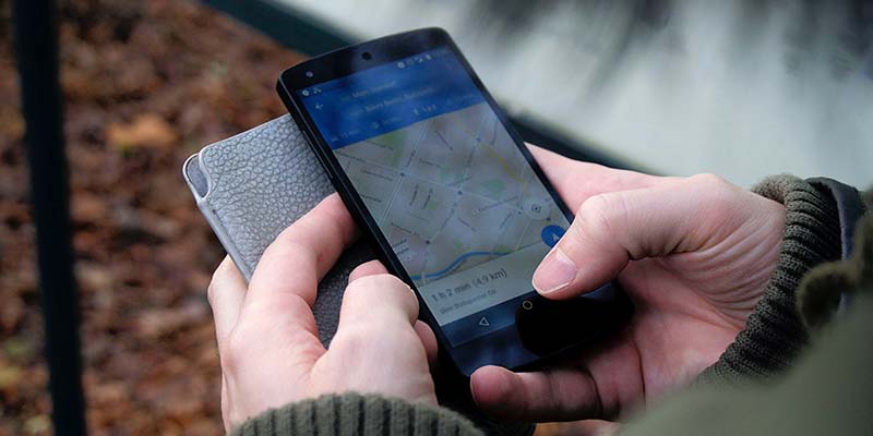 mão segurando um celular com um mapa na tela para escolher a localização